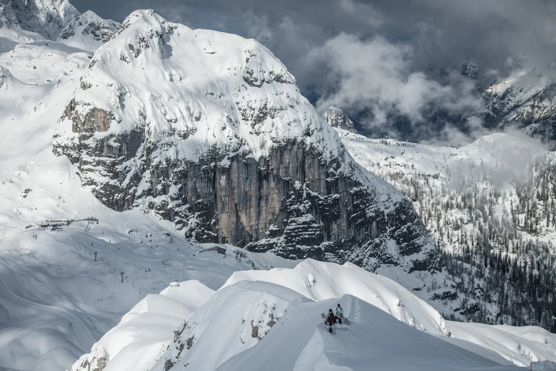 Snow-covered mountain landscape with rocky peaks and clouds